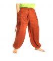 Pantalones Harem con estampado étnico y grandes bolsillos laterales naranjas.